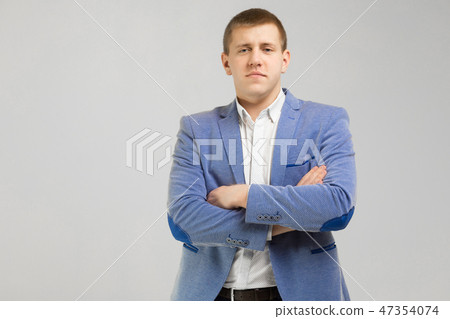 young man in a jacket folded arms isolated on light background young man in a jacket folded arms isolated on light background 47354074