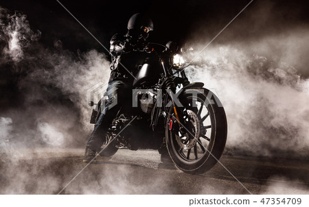Dark motorcycle driver in fog Dark motorcycle driver in fog 47354709