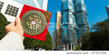 Feng Shui Master show FengShui Compass and turn direction to Force Energy, He wear black shirt to check North South West East for Luck and Prosperity to Design Building on Wind Water elements Signs 47355380