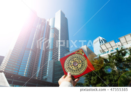 Feng Shui Master show FengShui Compass and turn direction to Force Energy, He wear black shirt to check North South West East for Luck and Prosperity to Design Building on Wind Water elements Signs 47355385