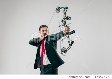 Businessman aiming at target with bow and arrow, isolated on white background Businessman aiming at target with bow and arrow, isolated on white background 47357576