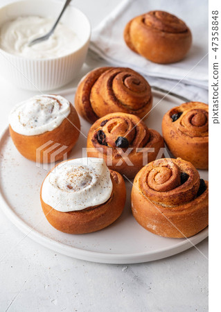 Delicious Cinnamon Rolls with cheese cream on a white plate. Copy space. Delicious Cinnamon Rolls with cheese cream on a white plate. Copy space. 47358848