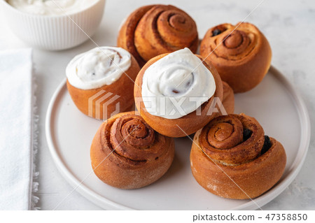 Delicious Cinnamon Rolls with cheese cream on a white plate. Copy space. Delicious Cinnamon Rolls with cheese cream on a white plate. Copy space. 47358850