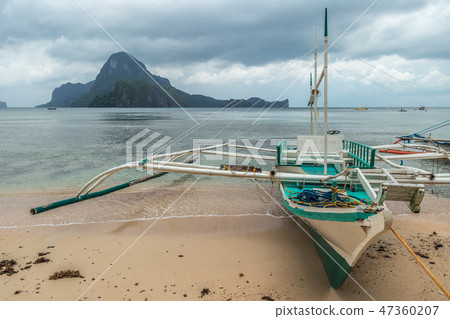 Fishing boat stranded and moored at the beach in a rainy morning in El Nido, Palawan, Philippines. 47360207