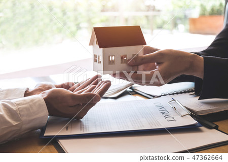 Estate agent sending house model to client after signing agreeme 47362664