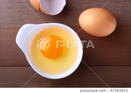 raw egg in white bowl ingredients for cooking. concept. Top view. raw egg in white bowl ingredients for cooking. concept. Top view. 47365653