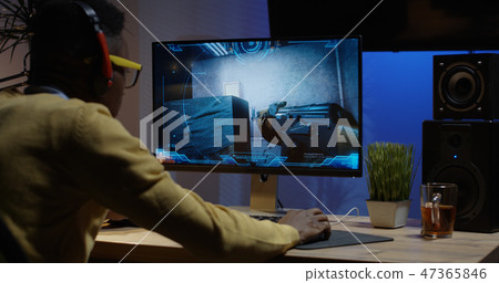 Young man playing video game inside a room Young man playing video game inside a room 47365846