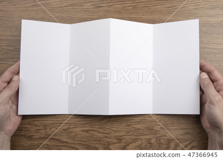 Mens hands holding white booklet 47366945