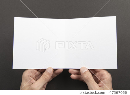 Mens hands holding white booklet 47367066
