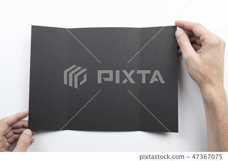 Mens hands holding black booklet 47367075