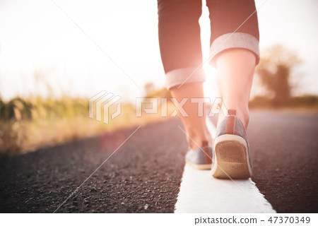 Closeup woman walking towards on the road side Closeup woman walking towards on the road side 47370349