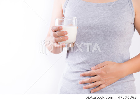Woman holding glass of milk having stomach ache Woman holding glass of milk having stomach ache 47370362