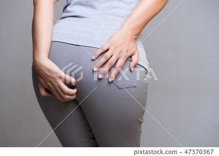 Woman suffering from hemorrhoids 47370367