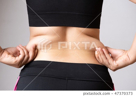 Fat woman hand holding excessive belly fat. Fat woman hand holding excessive belly fat. 47370373