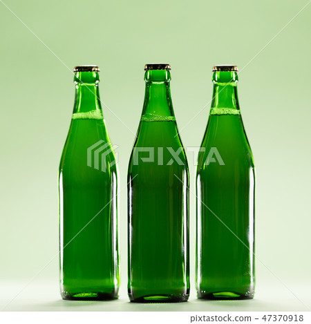 Three green bottles on a light green background. Three green bottles on a light green background. 47370918