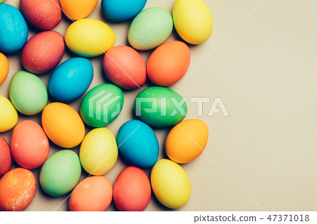 Couple of dyed eggs laying on a creamy background. 47371018