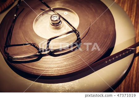 Pair of glasses laying on the top of retro film reel. Pair of glasses laying on the top of retro film reel. 47371019