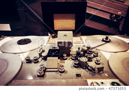 Film tape spooled on vintage cinematic reel. 47371053