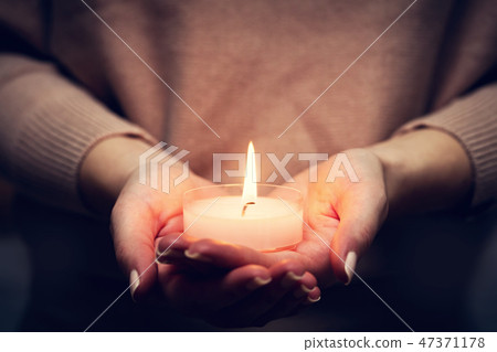 Candle light glowing in woman's hands. Praying, faith, religion Candle light glowing in woman's hands. Praying, faith, religion 47371178