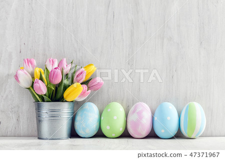 Easter eggs and a spring bouquet of tulips on a wooden table. 47371967