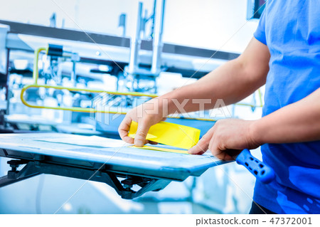 Man preparing fabric for screen printing. Man preparing fabric for screen printing. 47372001