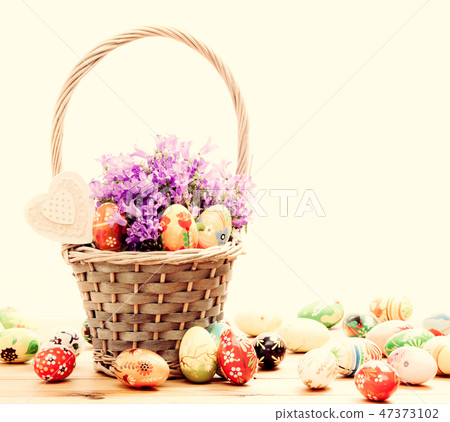 Colorful hand painted Easter eggs in basket and on wood. Handmade vintage decoration Colorful hand painted Easter eggs in basket and on wood. Handmade vintage decoration 47373102