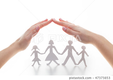 Paper family under hands in gesture of protection. 47373853