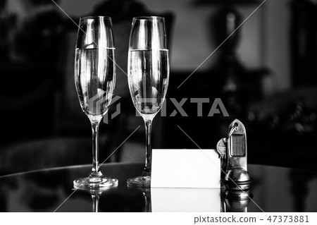 Full champagne glasses, antique keys and blank white card. Luxury hotel apartment 47373881