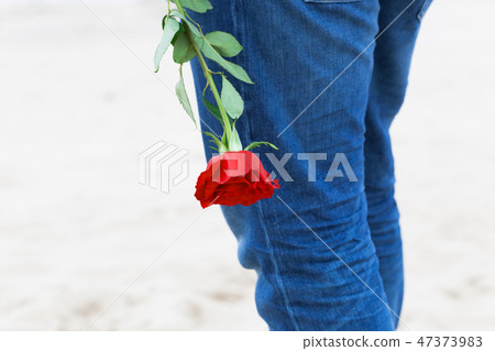 Man with a rose behind his back waiting for love. Romantic date on the beach 47373983