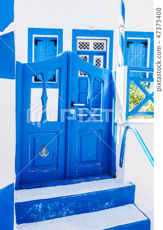 Traditional Greek stone house, blue gate and window shutters, Santorini island, Greece. Traditional Greek stone house, blue gate and window shutters, Santorini island, Greece. 47375408