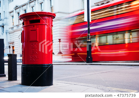 Traditional red mail letter box and red bus in motion in London, the UK. Traditional red mail letter box and red bus in motion in London, the UK. 47375739