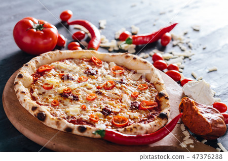 Pizza with hot pepper, cheese and meat spread 47376288