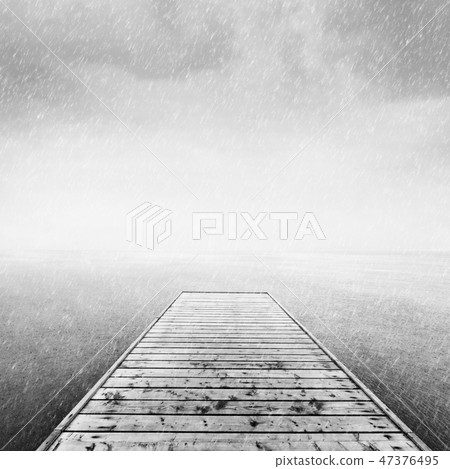 Wooden jetty, pier on deep cold sea, ocean. Raining sky Wooden jetty, pier on deep cold sea, ocean. Raining sky 47376495