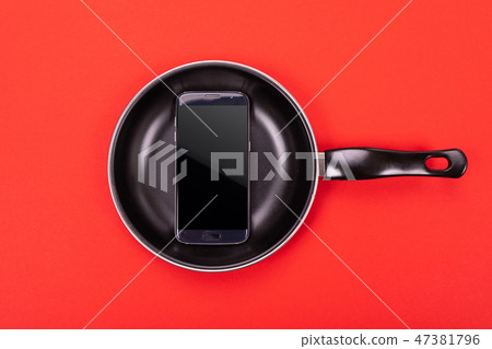 Mobile phone in pan isolated on red background Mobile phone in pan isolated on red background 47381796