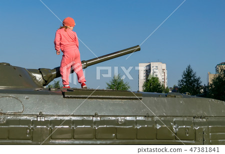 little girl, examines a military tank in the Park little girl, examines a military tank in the Park 47381841