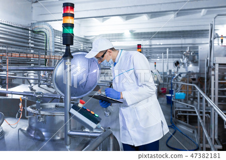 man in a white robe and mask makes notes standing in the shop 47382181