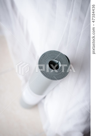 Pastel rolled yoga mat on white background 47384436