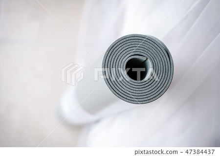 Pastel rolled yoga mat on white background 47384437