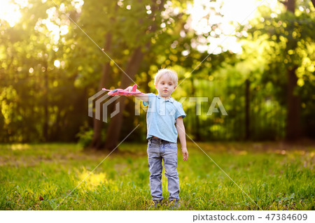 Boy playing with toy airplane in the sunny park. Boy playing with toy airplane in the sunny park. 47384609