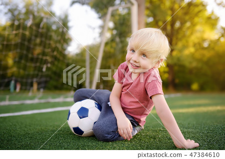 Boy having fun playing a soccer/football game Boy having fun playing a soccer/football game 47384610