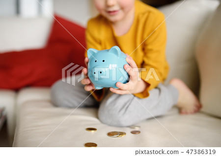 Little boy looks on moneybox  47386319