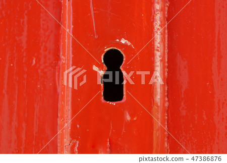 Detail of old wooden red painted door with heart shaped key hole 47386876