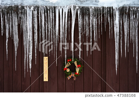 Beautiful icicles hanging from the house roof. 47388108