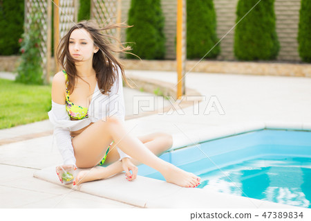 Pensive young woman in a bright swimsuit. 47389834