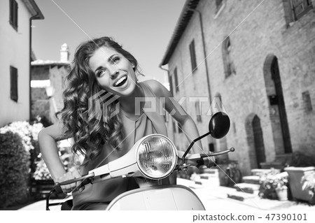 beautiful italian woman sitting on a italian scooter. 47390101