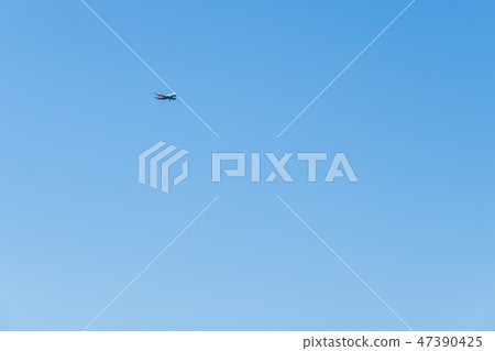 Red-and-white plane flying through the sky to land. Red-and-white plane flying through the sky to land. 47390425
