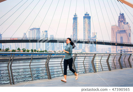 Girl running in a modern city environment Girl running in a modern city environment 47390565