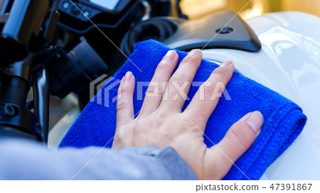 Men brushing motorcycle bikes 47391867