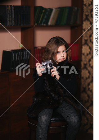 Little girl makes a photo on an old camera. Library 47393251