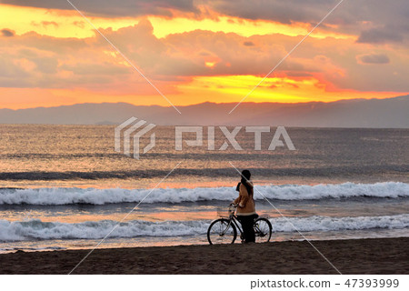 A sky and bicycle woman stained at the sunset at Kageuma Coast A sky and bicycle woman stained at the sunset at Kageuma Coast 47393999